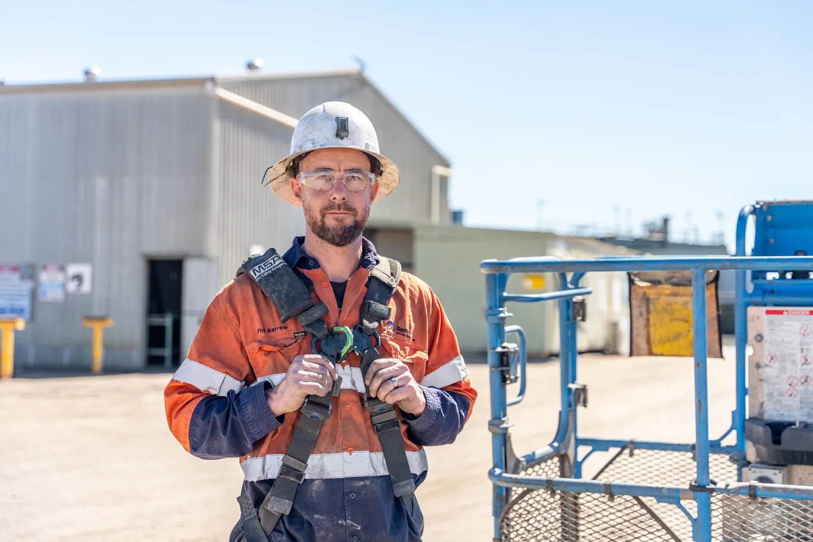 An Aeris worker holds the straps of his fall-arrest harness